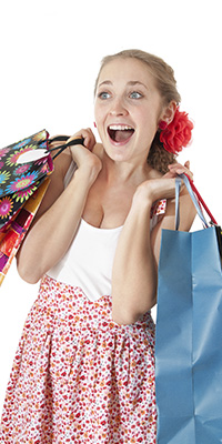 Mentality Shopperprofielen – Impulsieve shoppers, blonde vrouw in een jurk die enthousiast verrast reageert.