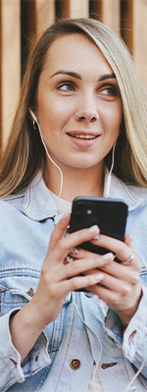Mentality Mediaprofielen – Nieuwsgierige overzichtzoekers, jonge vrouw met lang blond haar die op haar telefoon kijkt.
